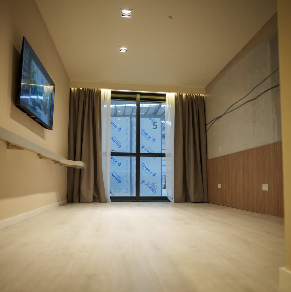 Habitación terminada con TV y cortinas instaladas